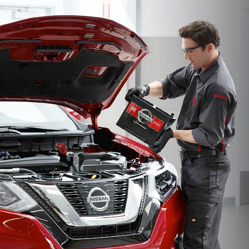 Nissan Parts Coupon Nissan Service Technician replacing a car battery