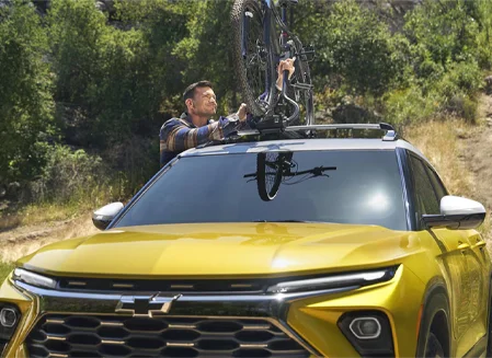 Man putting a bike on a Chevy Trailblazer